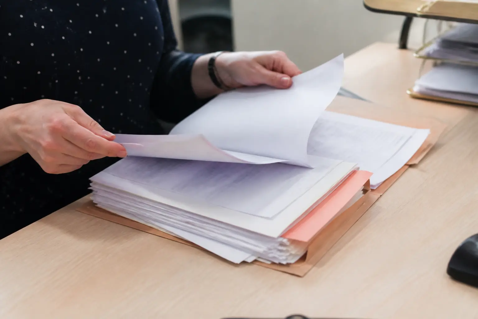 Dossier de demande de logement examiné sur un bureau, mains feuilletant les pages, inscription à l'ordre du jour d'une cal
