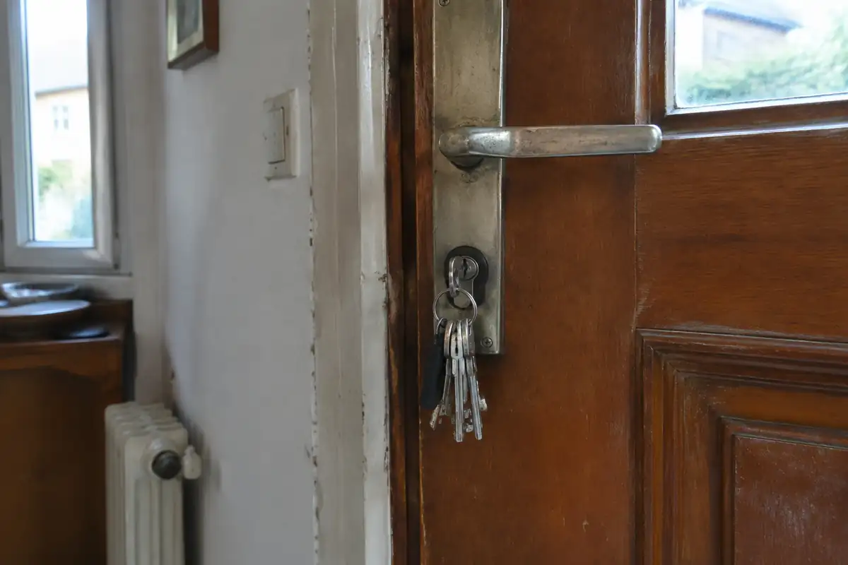 Trousseau de clés resté dans la serrure d'une porte d'entrée en bois