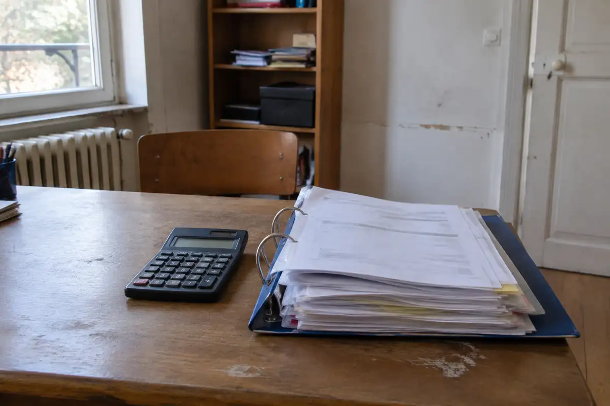 Calculatrice et classeur de pièces justificatives sur un bureau